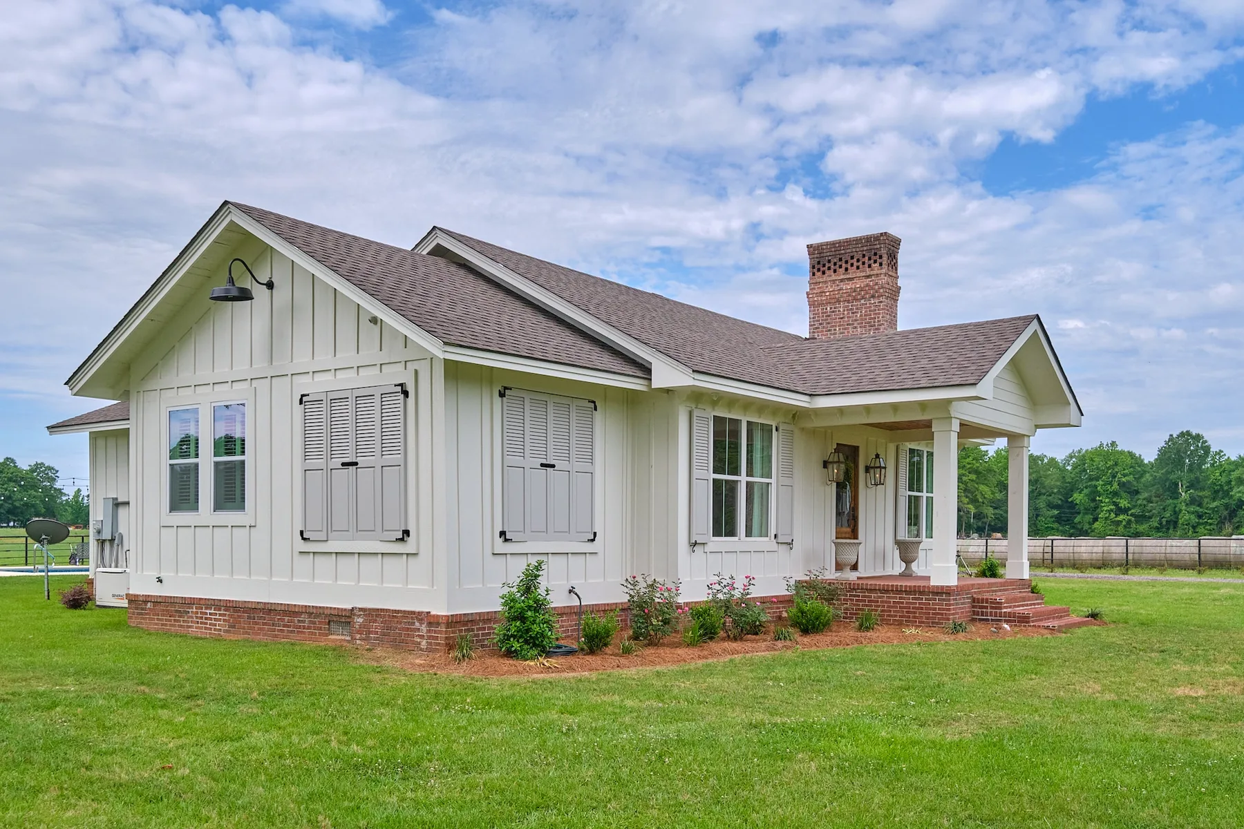 Farmhouse-style home with gray cedar louvered exterior shutters