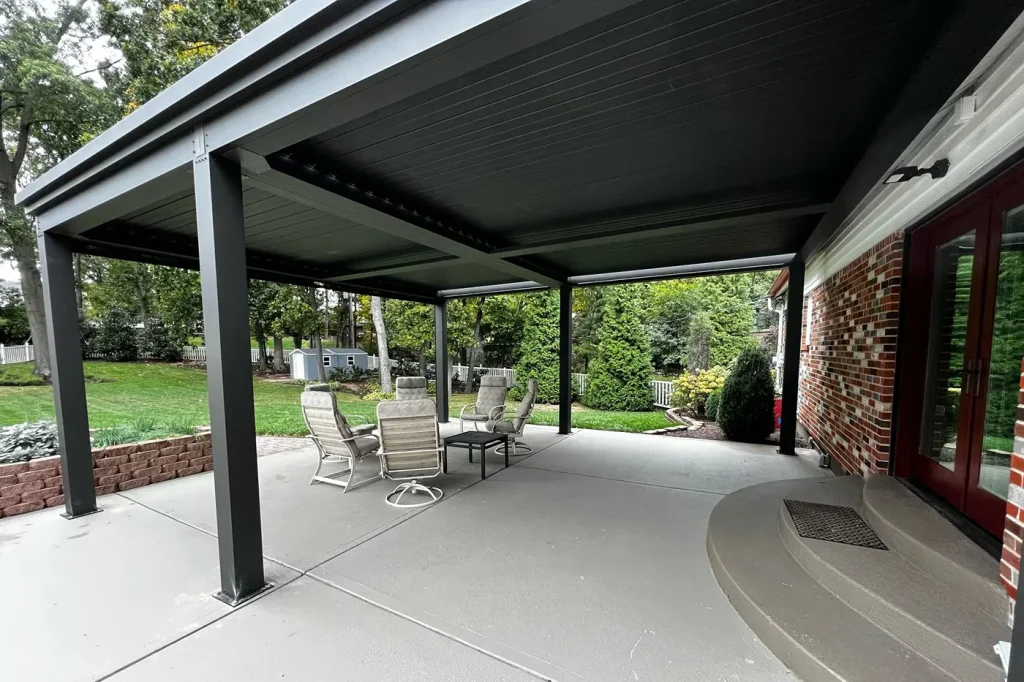Dark aluminum louvered pergola over a backyard patio