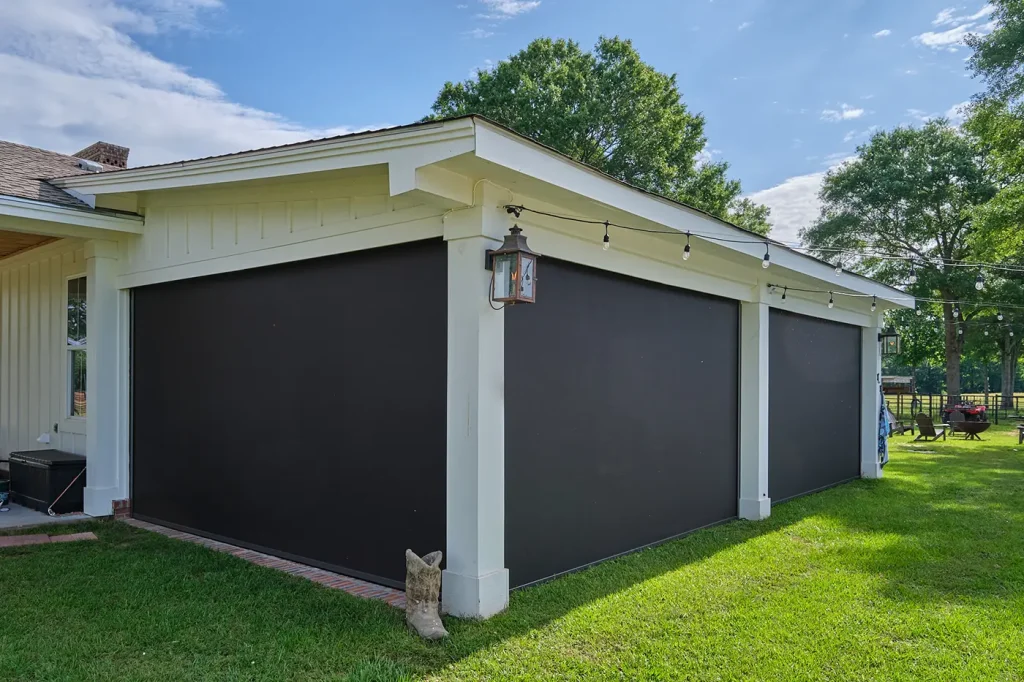Dark motorized exterior screens enclosing a covered patio