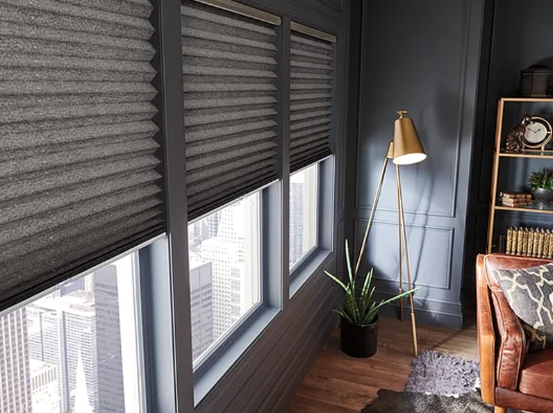 Charcoal cellular shades lowered over floor-to-ceiling windows in a navy blue study