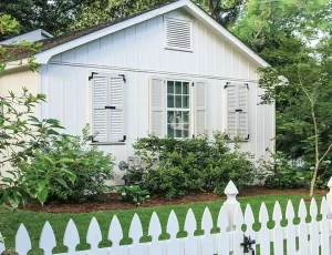 white house with white exterior shutters, white picket fence